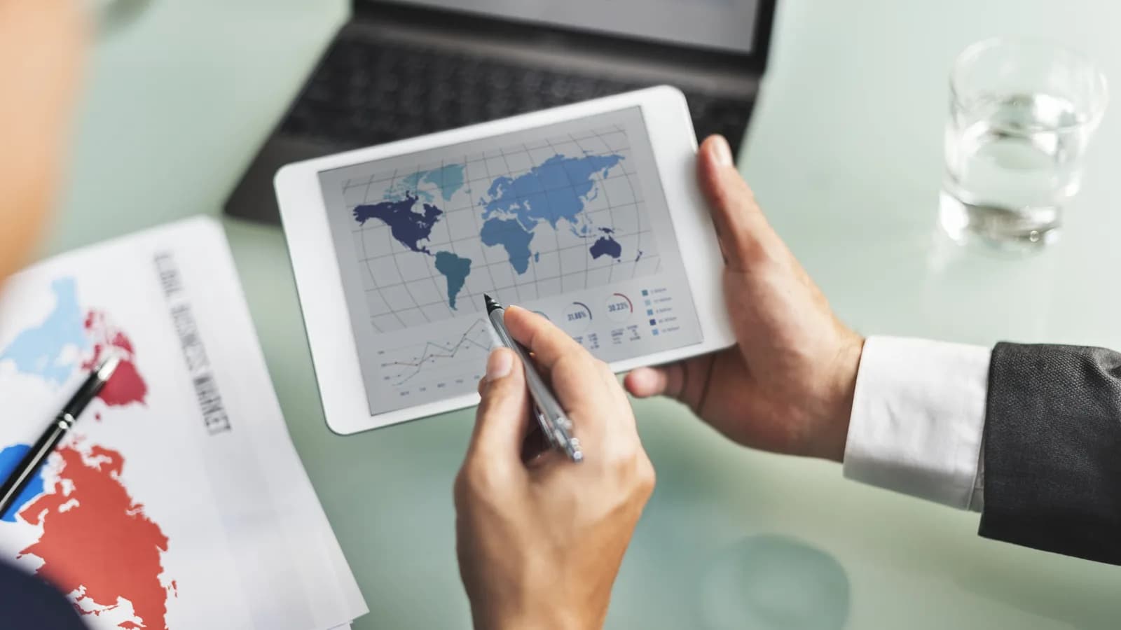 Analyse de données patrimoniales internationales sur tablette et ordinateur, symbole d’une stratégie d’expatriation