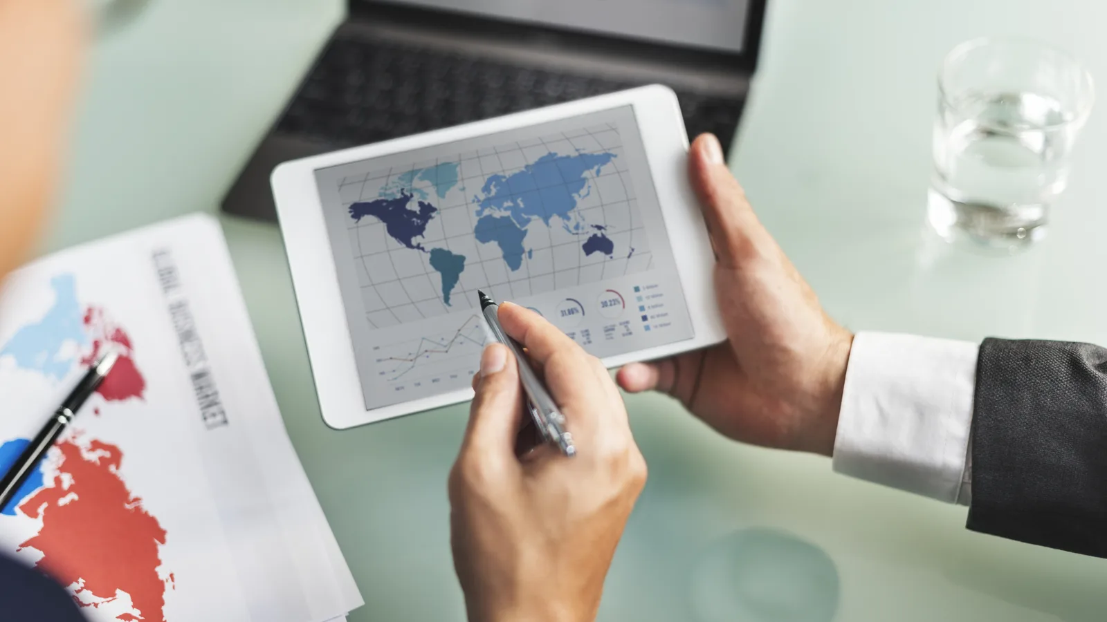 Analyse de données patrimoniales internationales sur tablette et ordinateur, symbole d’une stratégie d’expatriation